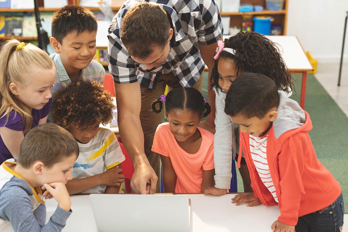 Teacher with students using a laptop